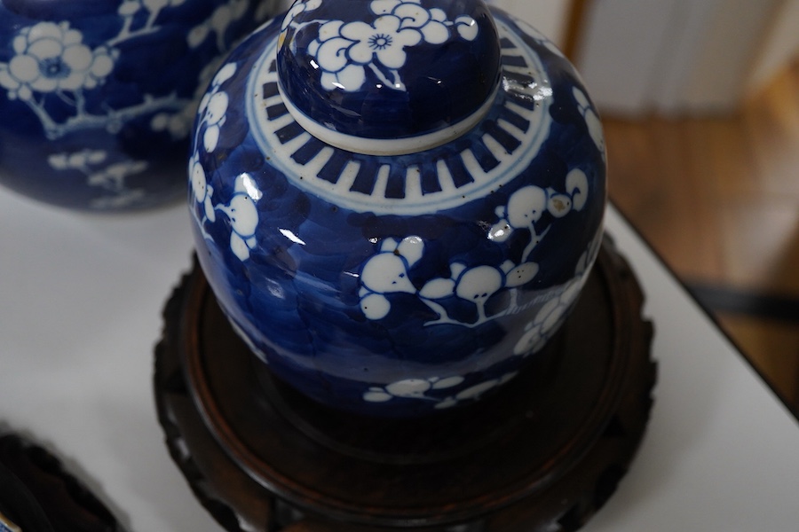An 18th century Chinese blue and white dish, two jars (one without cover), a teapot and two carved wooden stands